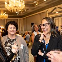 Four event attendees standing in circle. One is speaking to group while others give her their attention